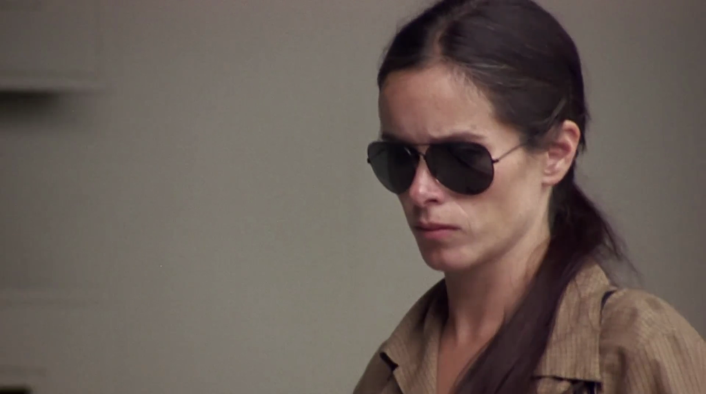 Emily (Geraldine Chaplin), fresh out of prison, cloaked in sunglasses in Remember My Name.