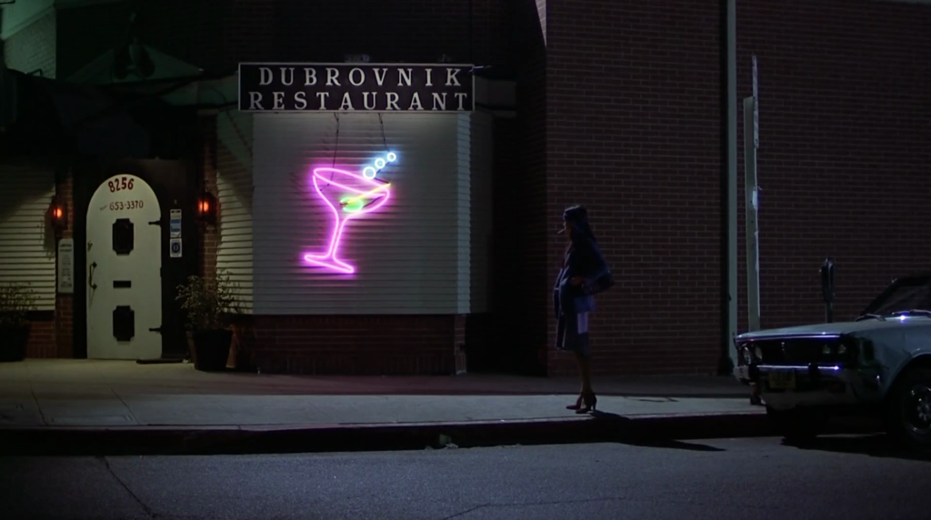 Emily (Geraldine Chaplin) stands outside the Dubrovnik Restaurant in Remember My Name. 