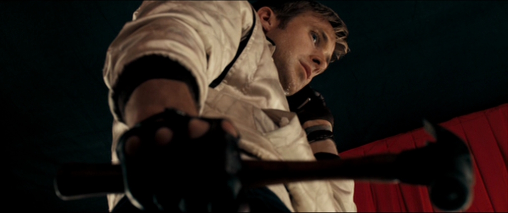  A still from Drive. The driver clenches a hammer in one hand and holds a phone to his ear in the other.