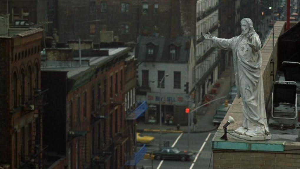 A dingy but large statue of Jesus, arms outstretched, perched atop an office building in Little Italy, from the film Mean Streets (1973).