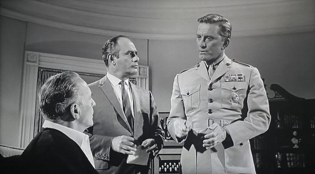 President Jordan Lyman (Fredric March) and White House advisor Paul Girard (Martin Balsam) hear evidence of a military coup from Colonel Martin J. Casey (Kirk Douglas) in John Frankenheimer’s Seven Days in May (1964).