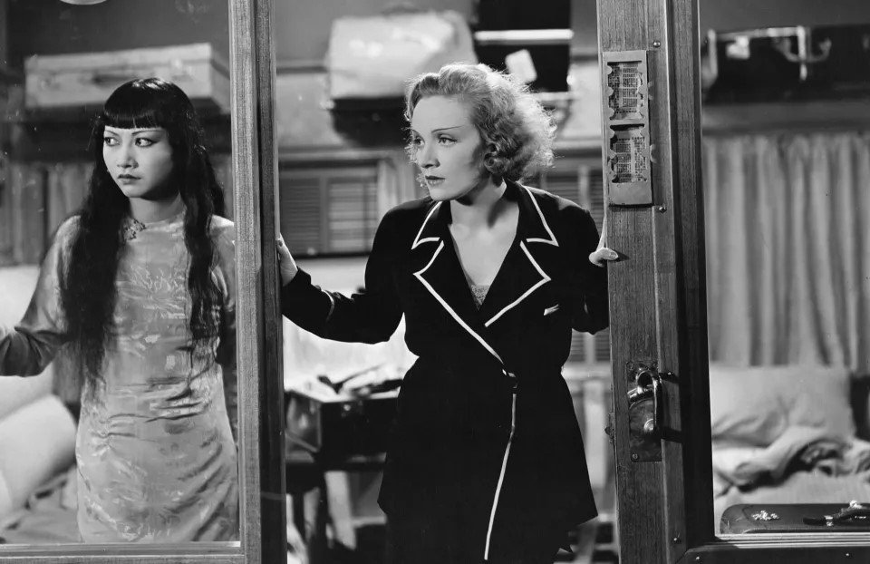 Two women, Hui Fei and Shanghai Lily, stand looking out of their train compartment window, separated but together