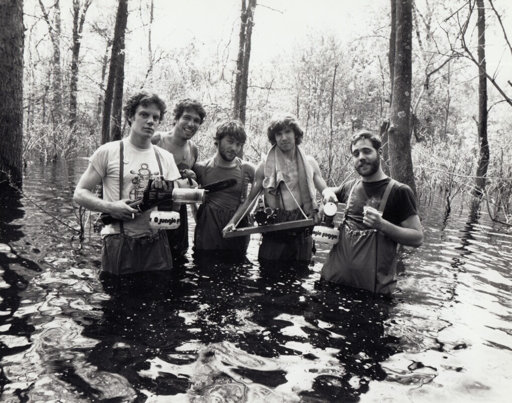 Five men stand waist deep in water with film equipment