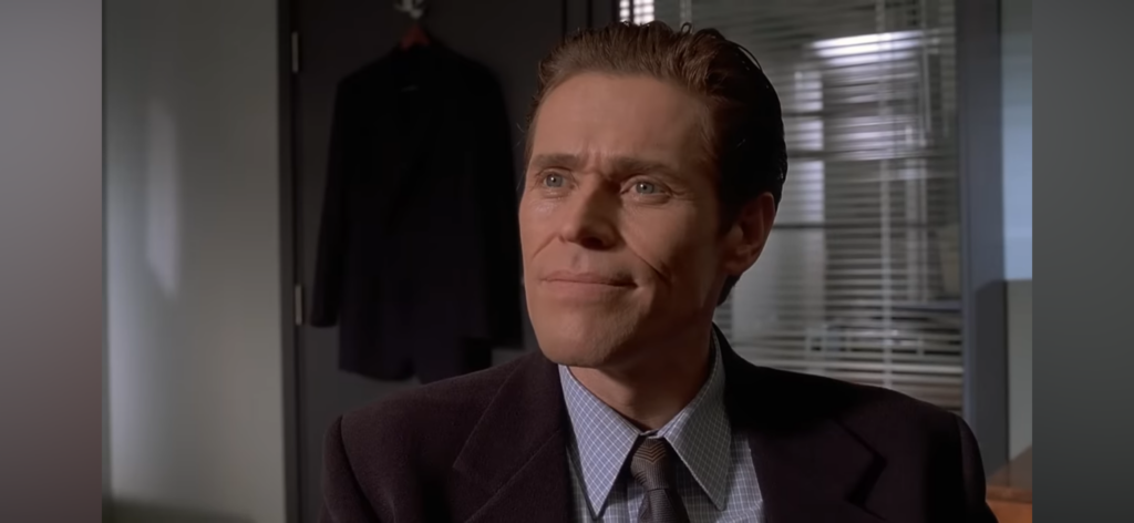 Willem Dafoe as private detective Donald Kimball sits in Patrick Bateman’s office.