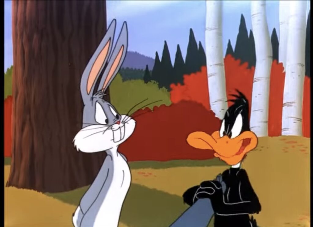 Bugs Bunny and Daffy Duck standing in a forest, Daffy holds the tip of a shotgun barrel aimed at him.