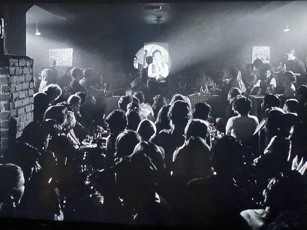 A black and white image of a crowded club.