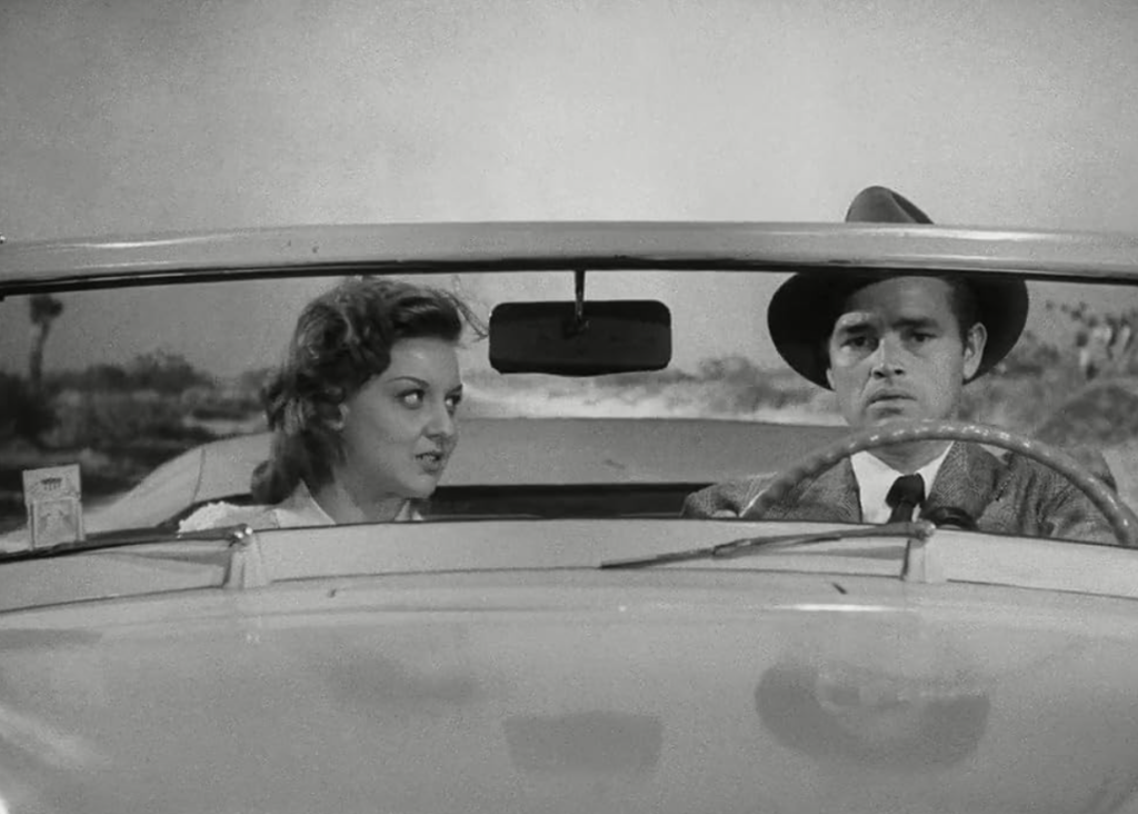 Al and Vera sit in Haskell’s car, driving on the highway. 