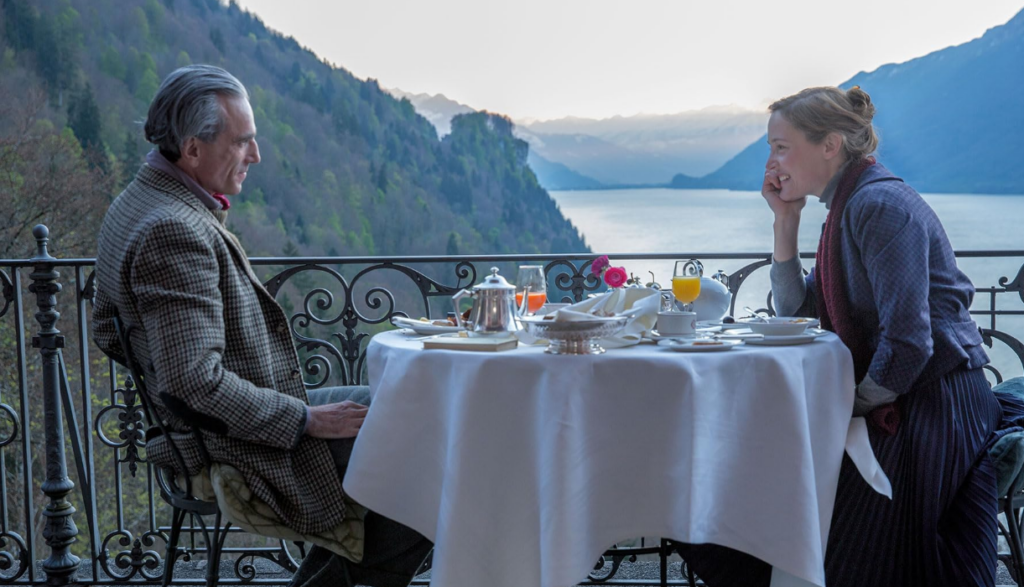 Alma and Reynolds eat breakfast overlooking a lake.