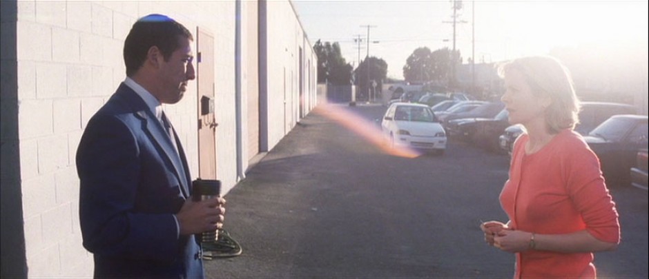 Emily Watson as Lena Leonard in red-pink outfit, with Adam Sandler as Barry Egan in blue suit.